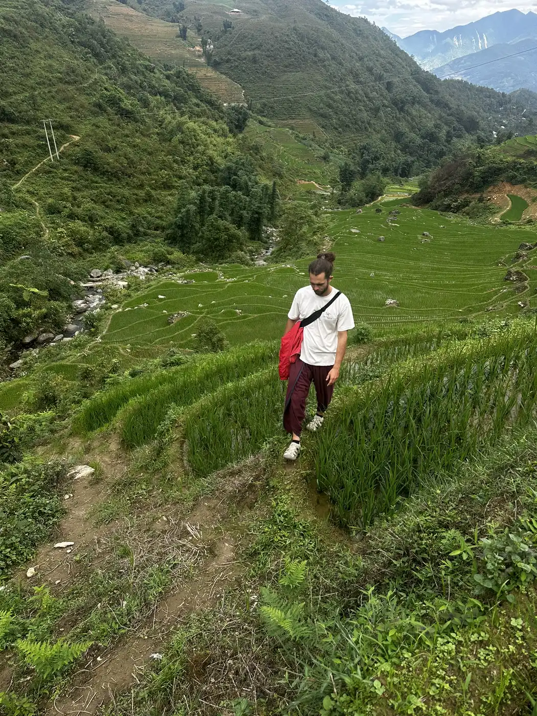 Hiker crossing a steep rice terrace trail in the Sa Pa valley