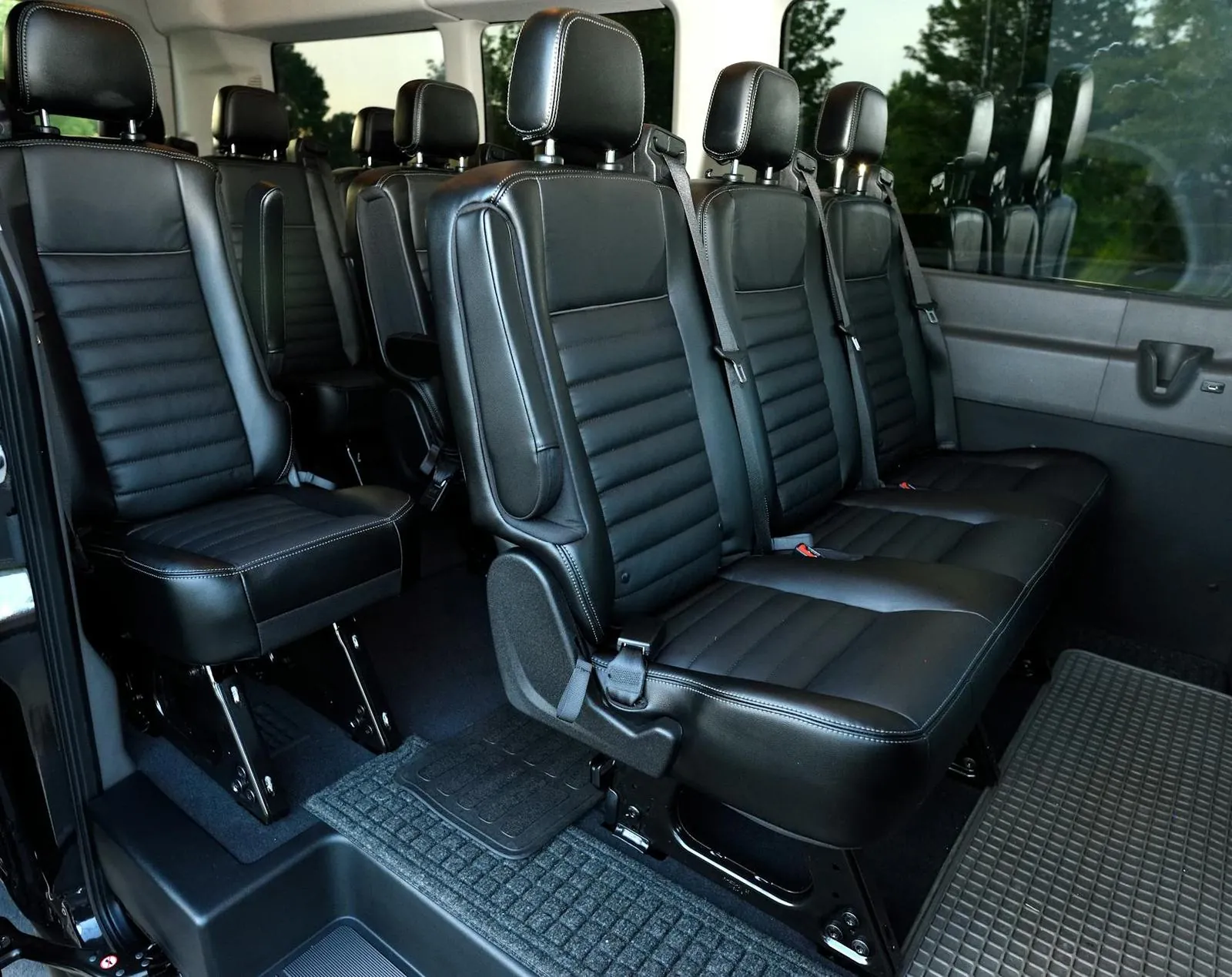 Black leather interior of a Kia Carnival — the upgraded vehicle for door-to-door visa runs out of Da Nang