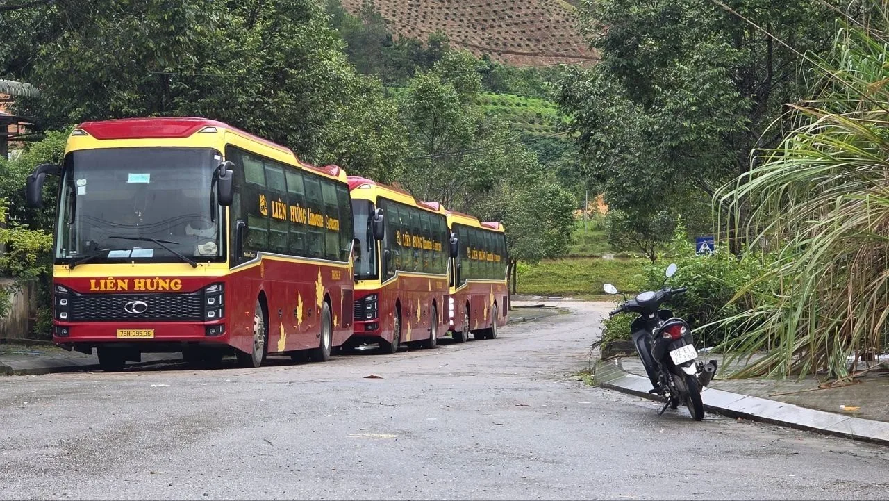 Wide view of the Lao Bao border crossing area with tour buses parked near the mountains