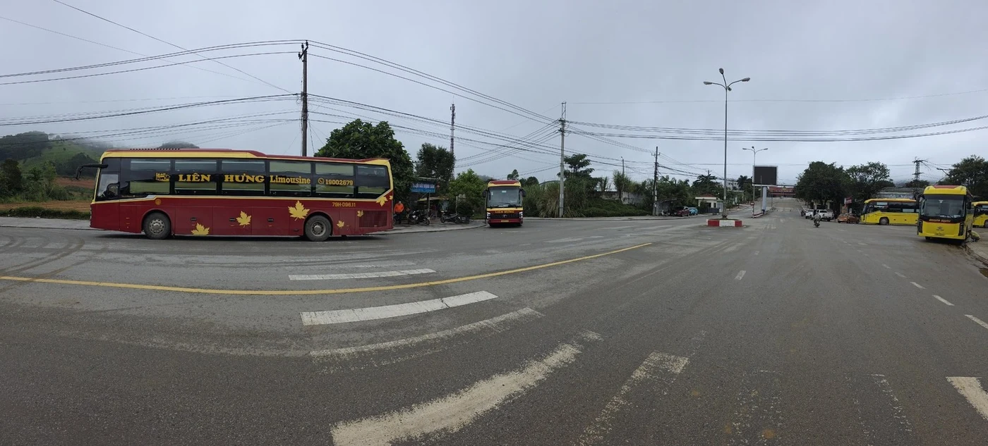 Wide panorama of the Lao Bao border crossing area with buses and mountains