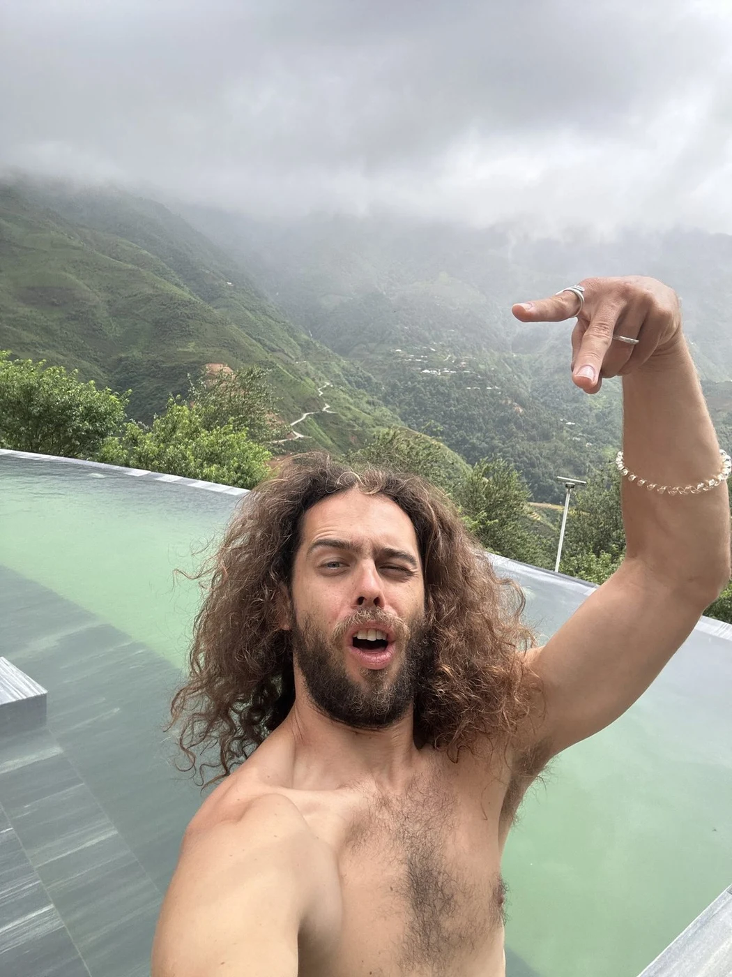 Traveler at an infinity pool overlooking misty mountains in Sapa, Vietnam