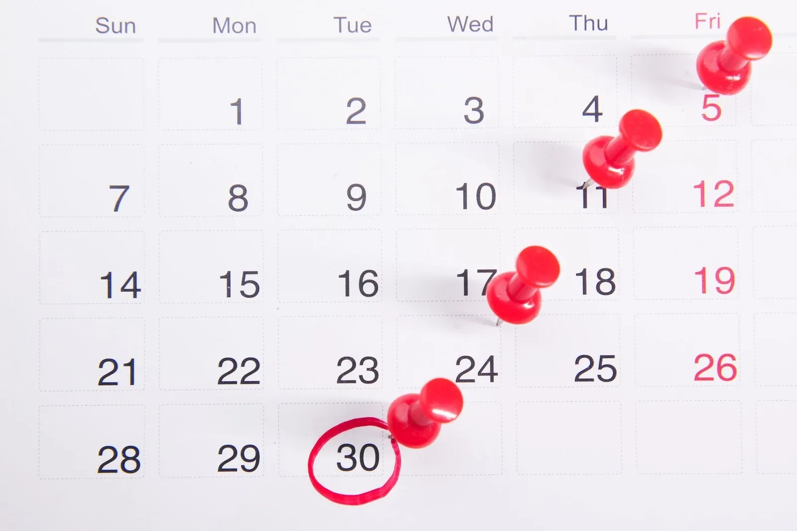 Calendar marked with red pins counting toward a deadline