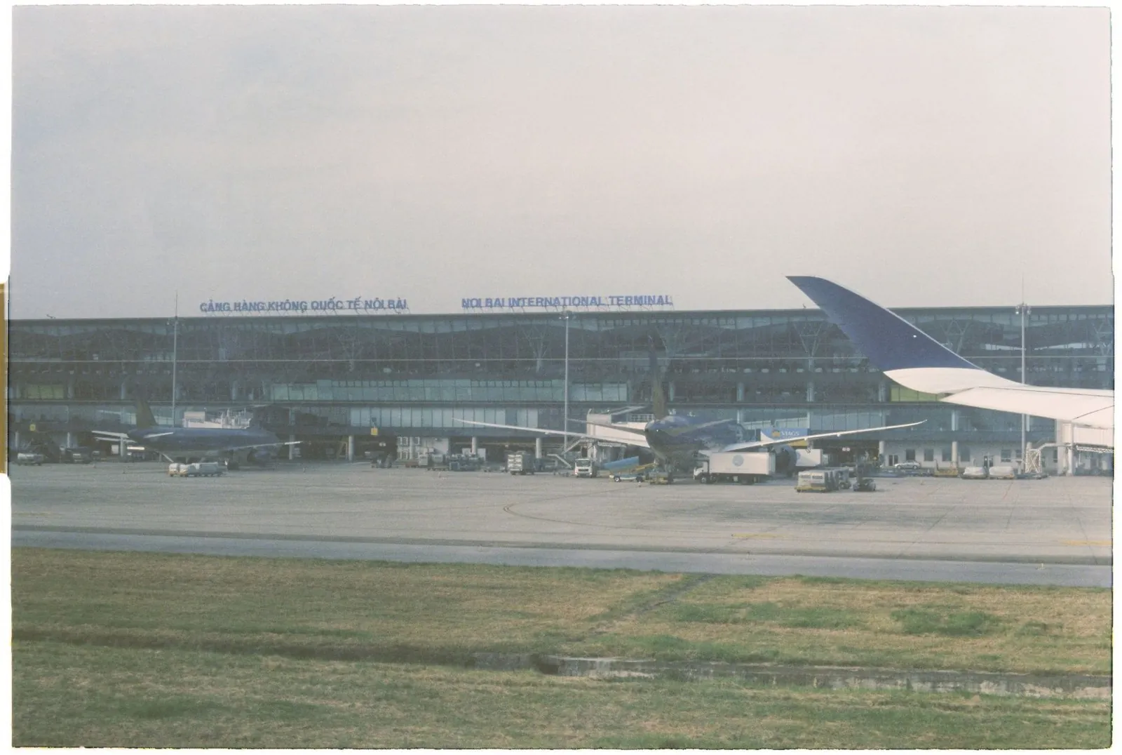 Noi Bai International Terminal building in Hanoi with a Vietnam Airlines plane at the gate
