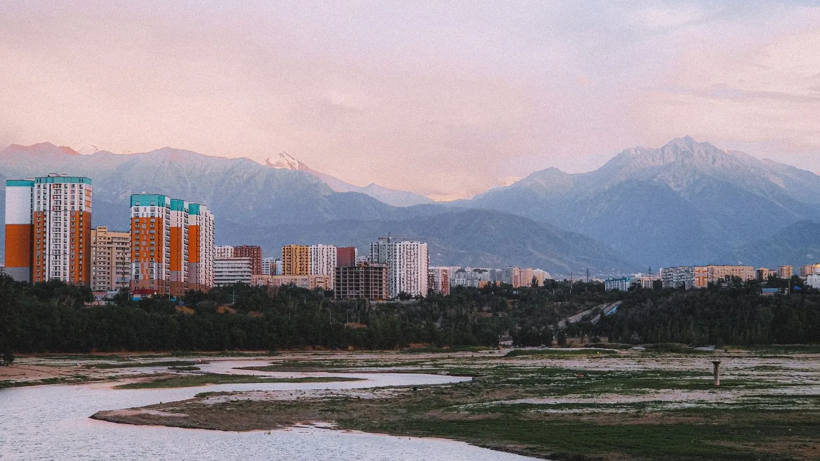 Almaty, Kazakhstan skyline with mountains at sunset