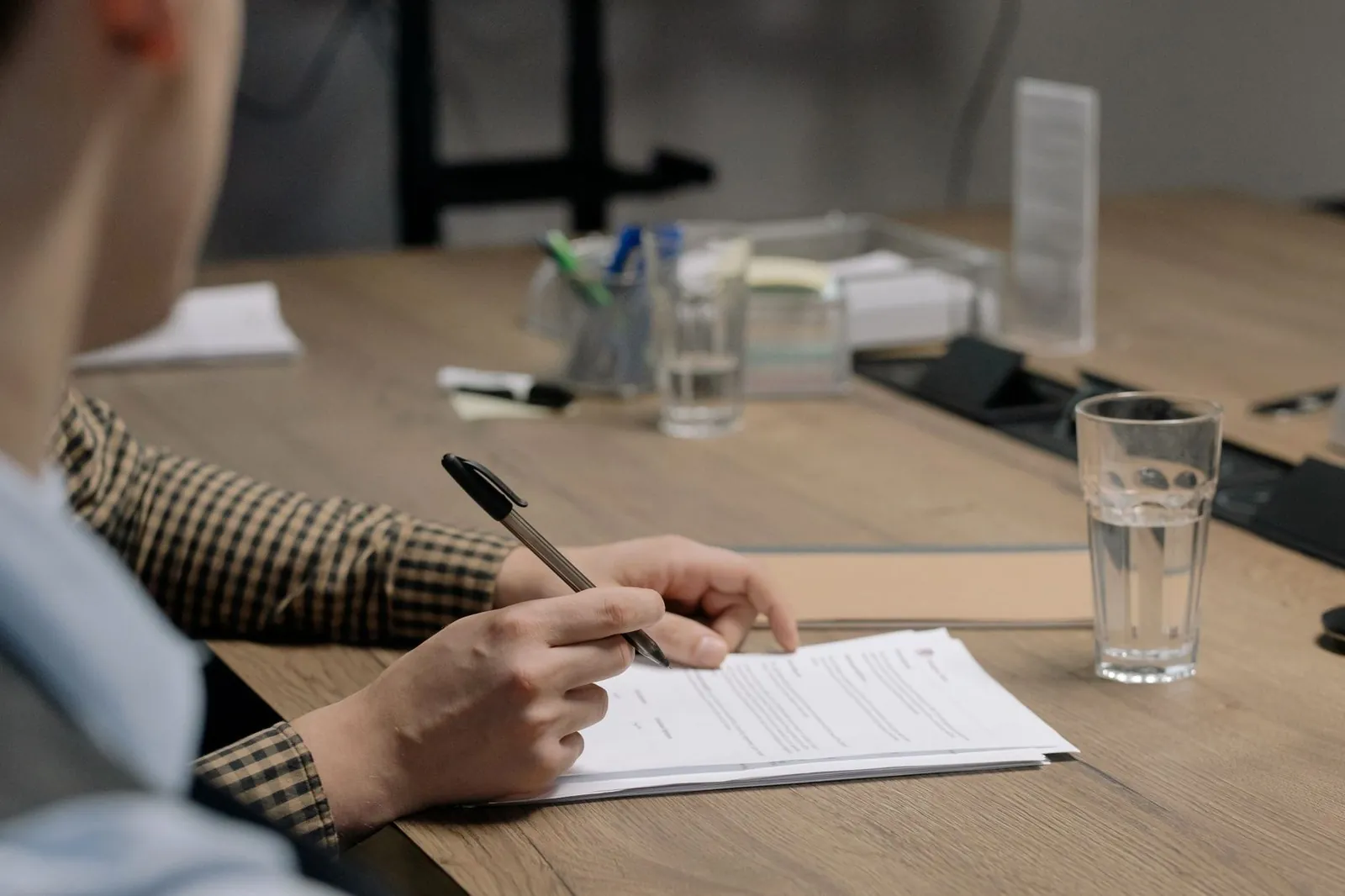 Businessperson signing a visa application document at a desk