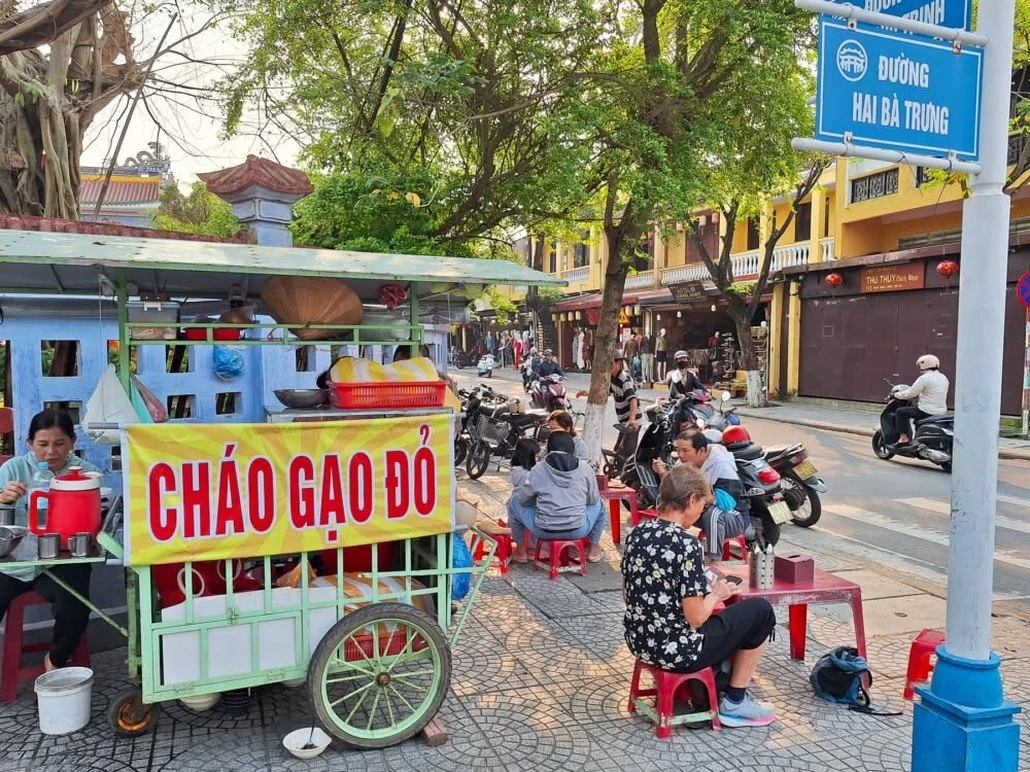 A street food cart selling rice porridge on a Vietnamese sidewalk