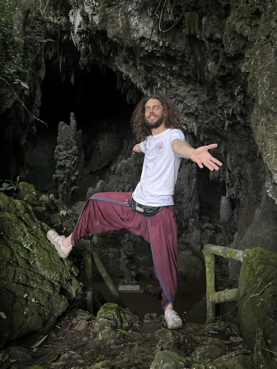 Traveler resting on a wooden bridge railing in dense tropical jungle