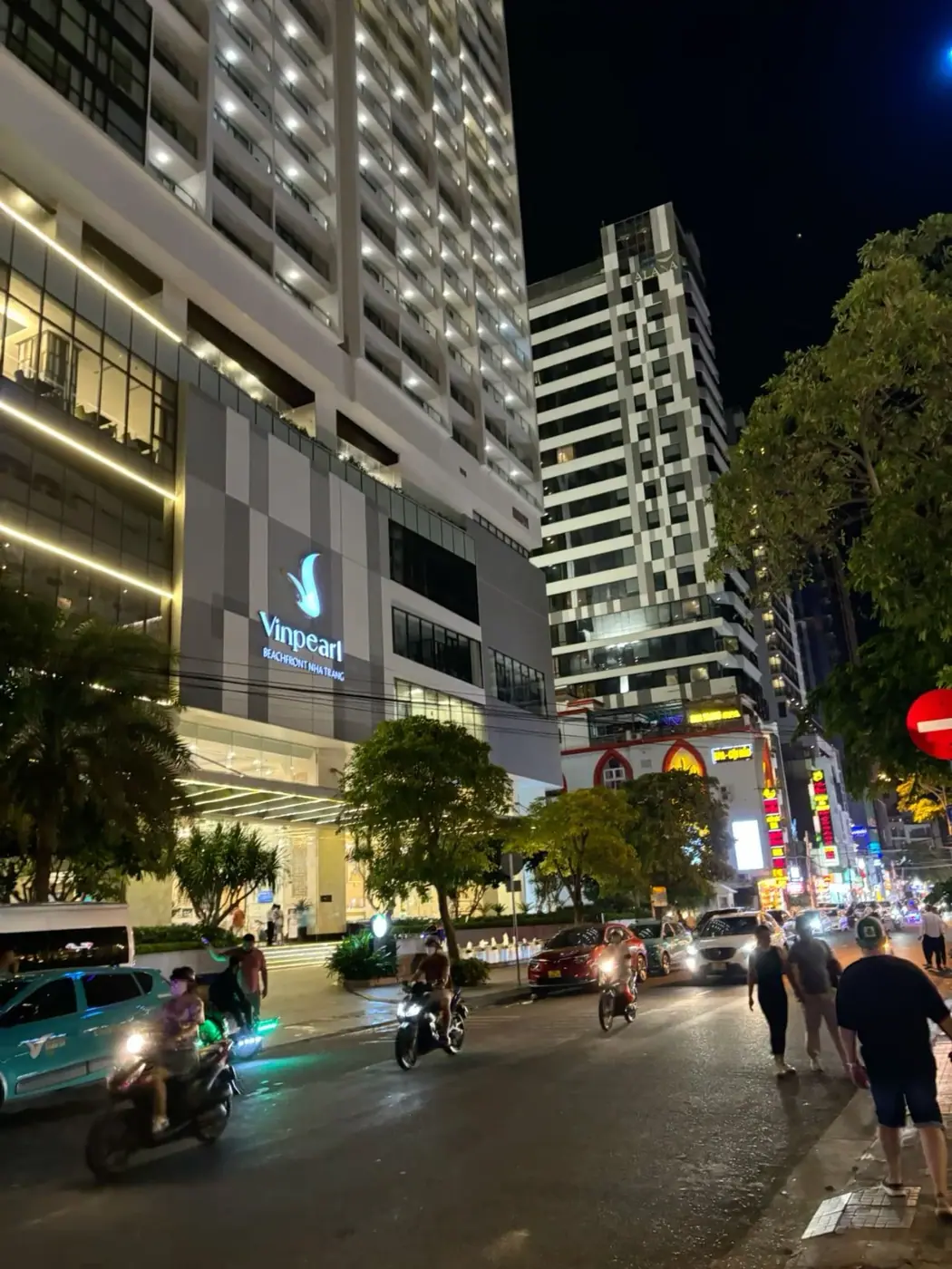 hotel towers lit up at night on a Nha Trang street