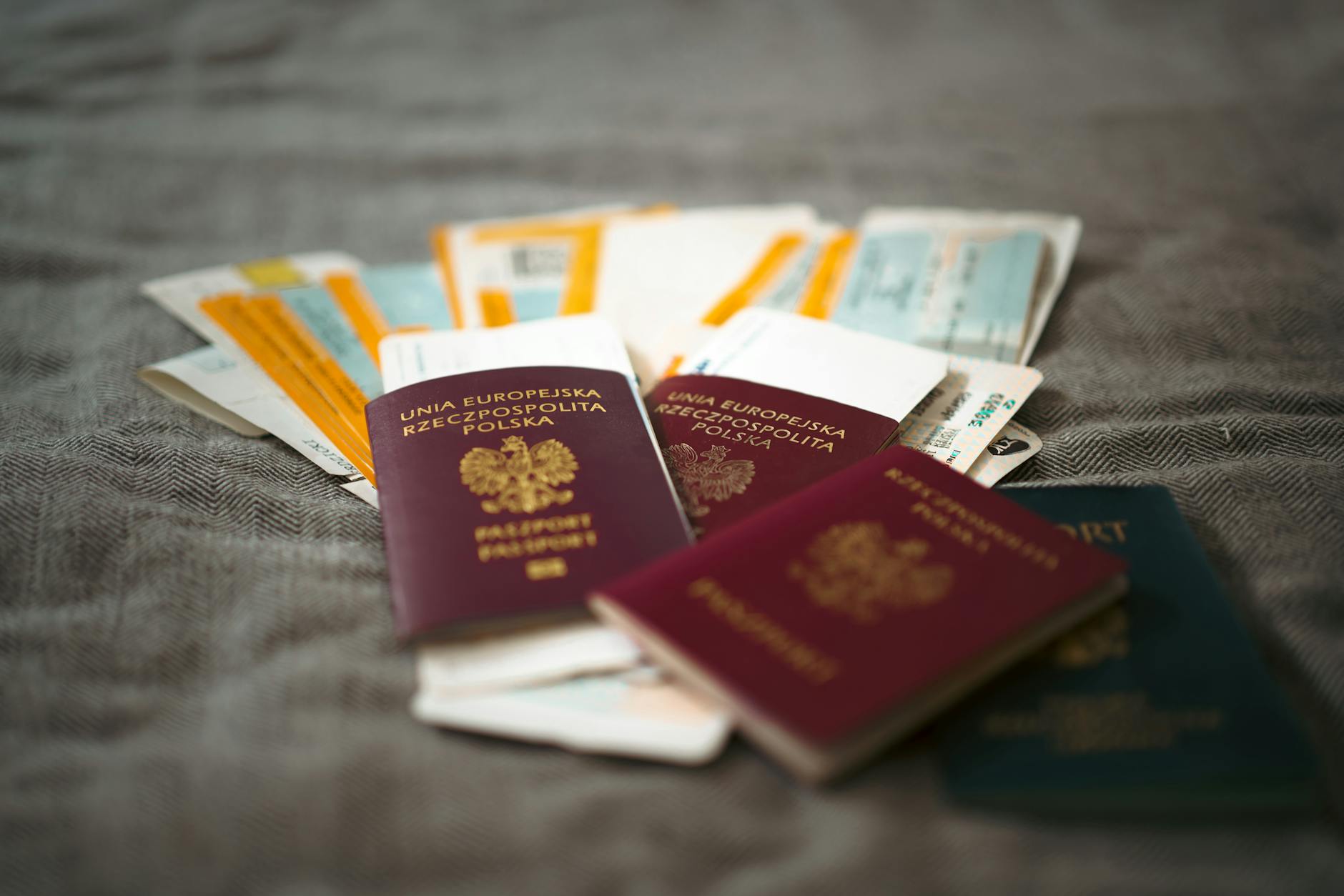 Multiple passports and boarding passes spread out on a surface, representing international travel documents for visa runs