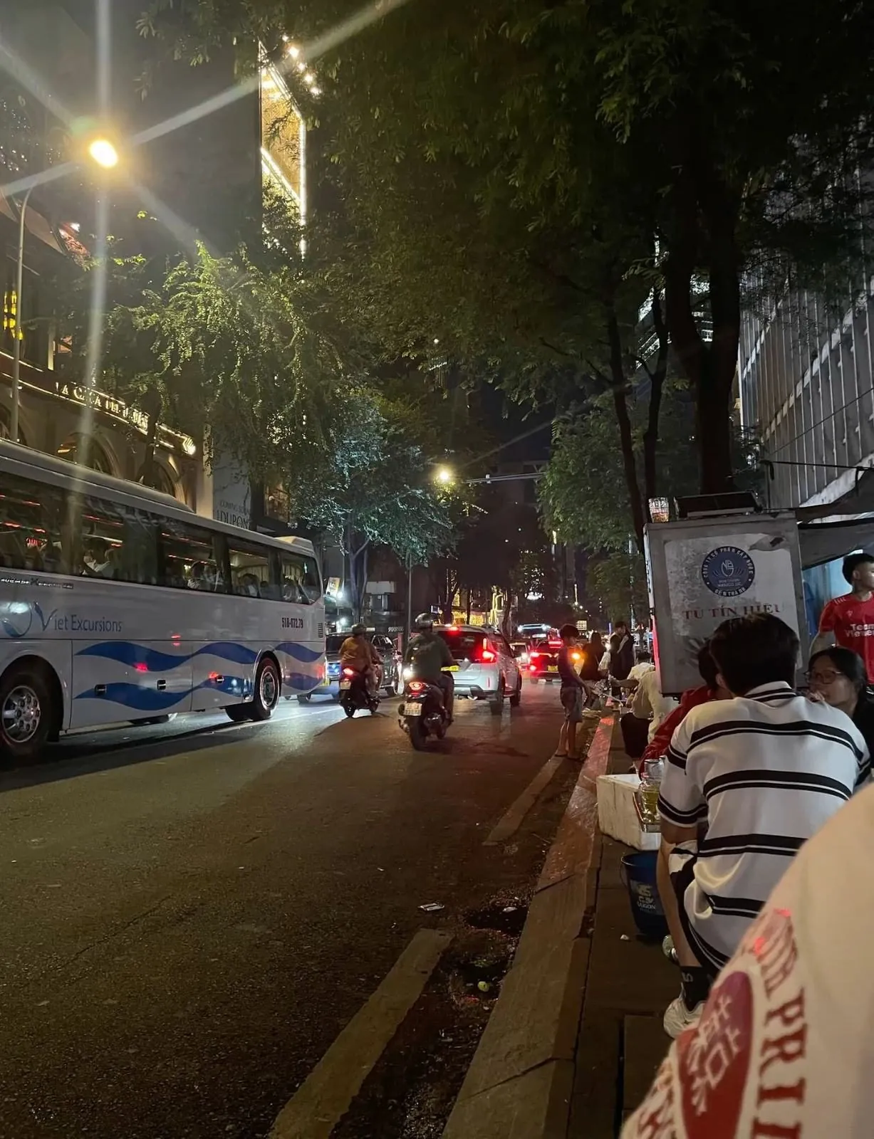evening street in Da Nang with a tour bus and motorbikes