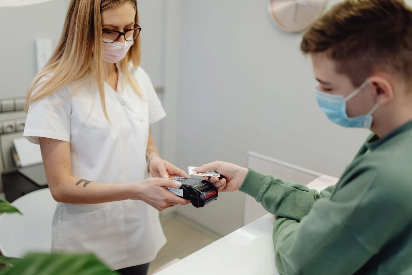 Patient paying by card at a clinic reception terminal