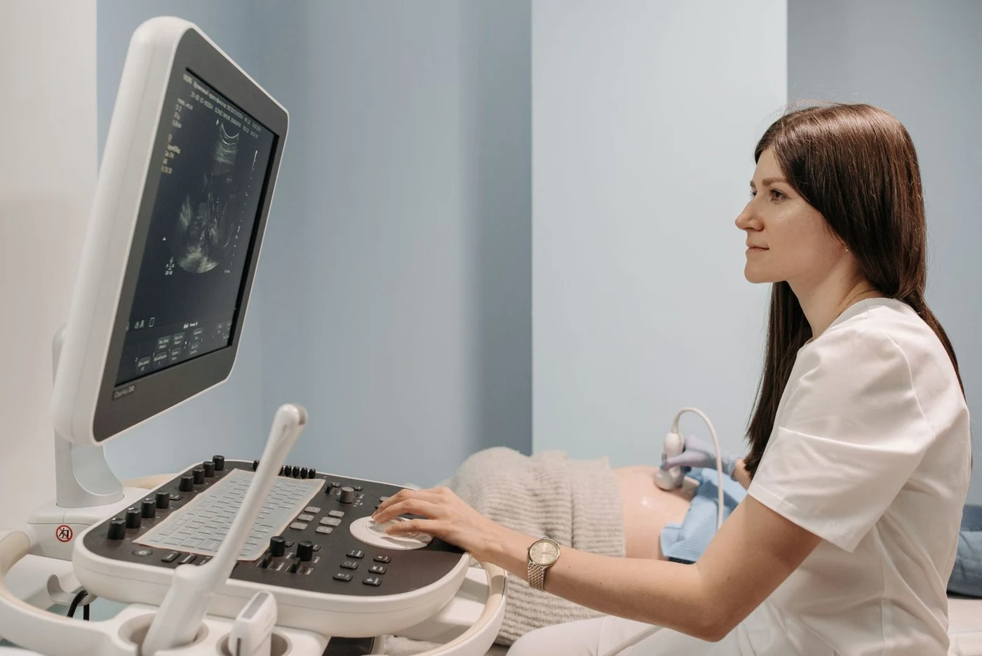 Doctor performing an ultrasound scan on a patient lying down