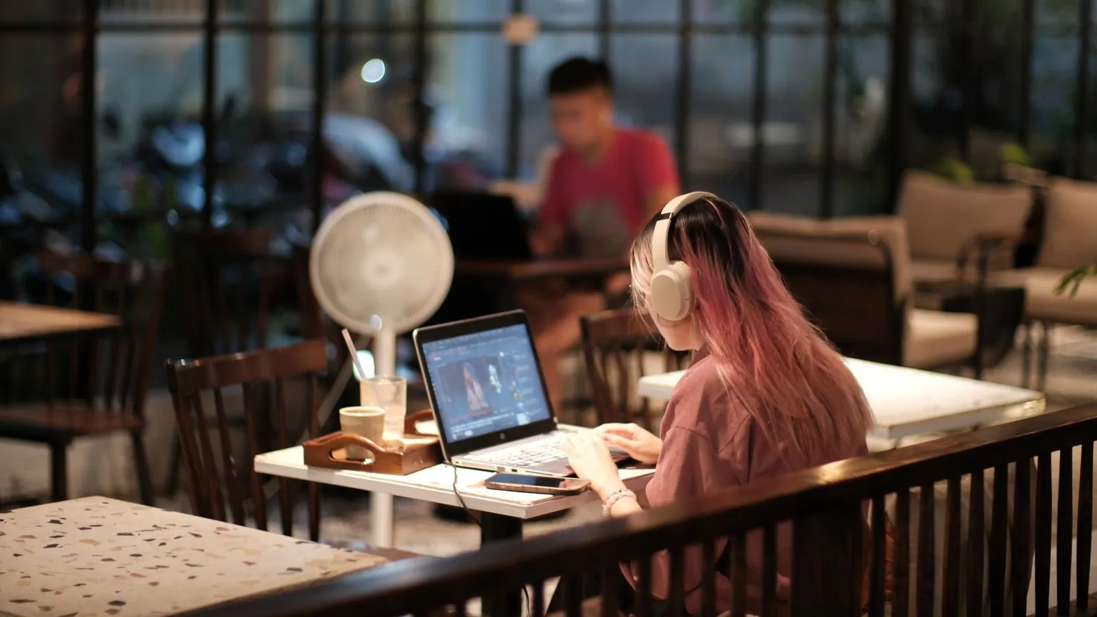 A remote worker on a laptop in a Vietnamese cafe at night