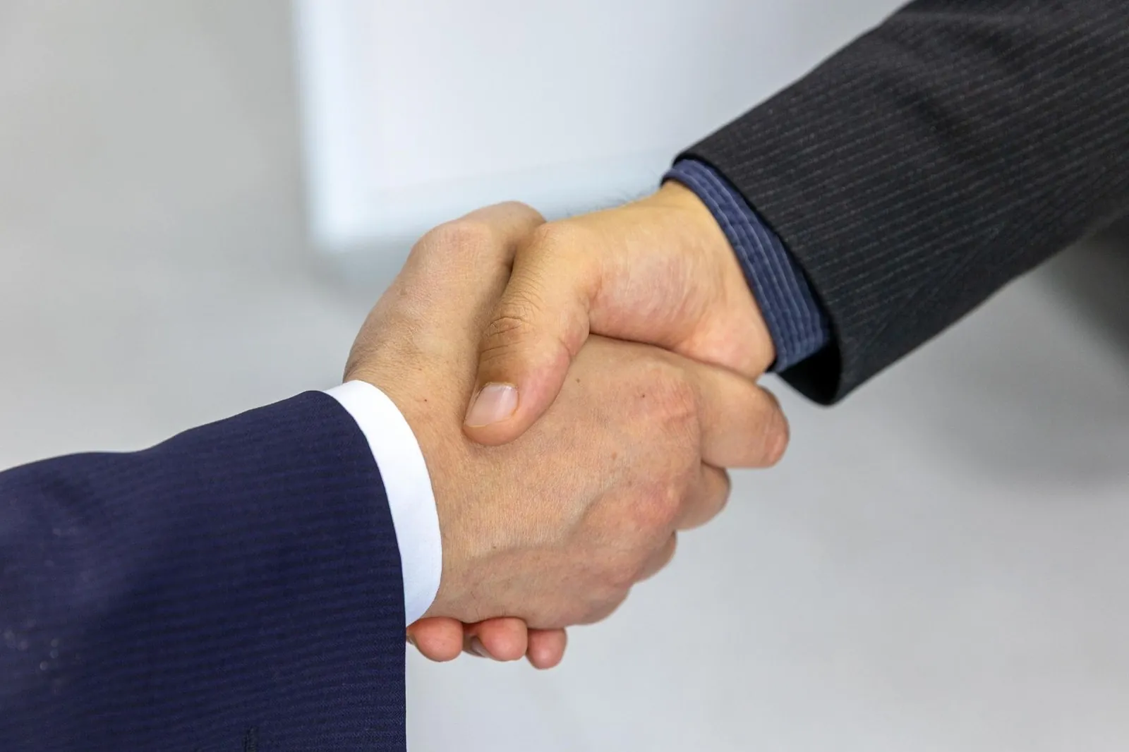 Two colleagues shaking hands in an office after a hiring agreement